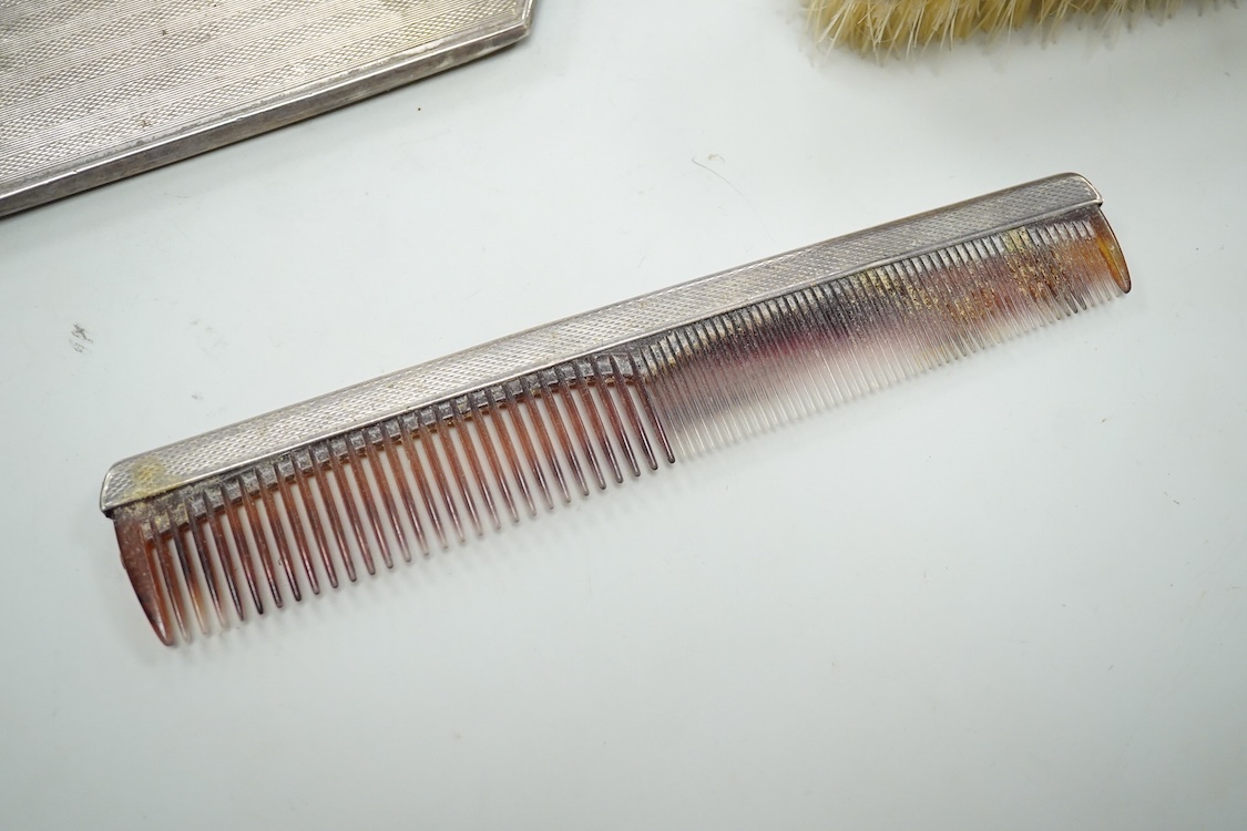 An Elizabeth II engine turned silver Art Deco style four pieced dressing table mirror, brush and comb set, W.I. Broadway & Co, Birmingham, 1961/63/65, mirror 27.8cm.